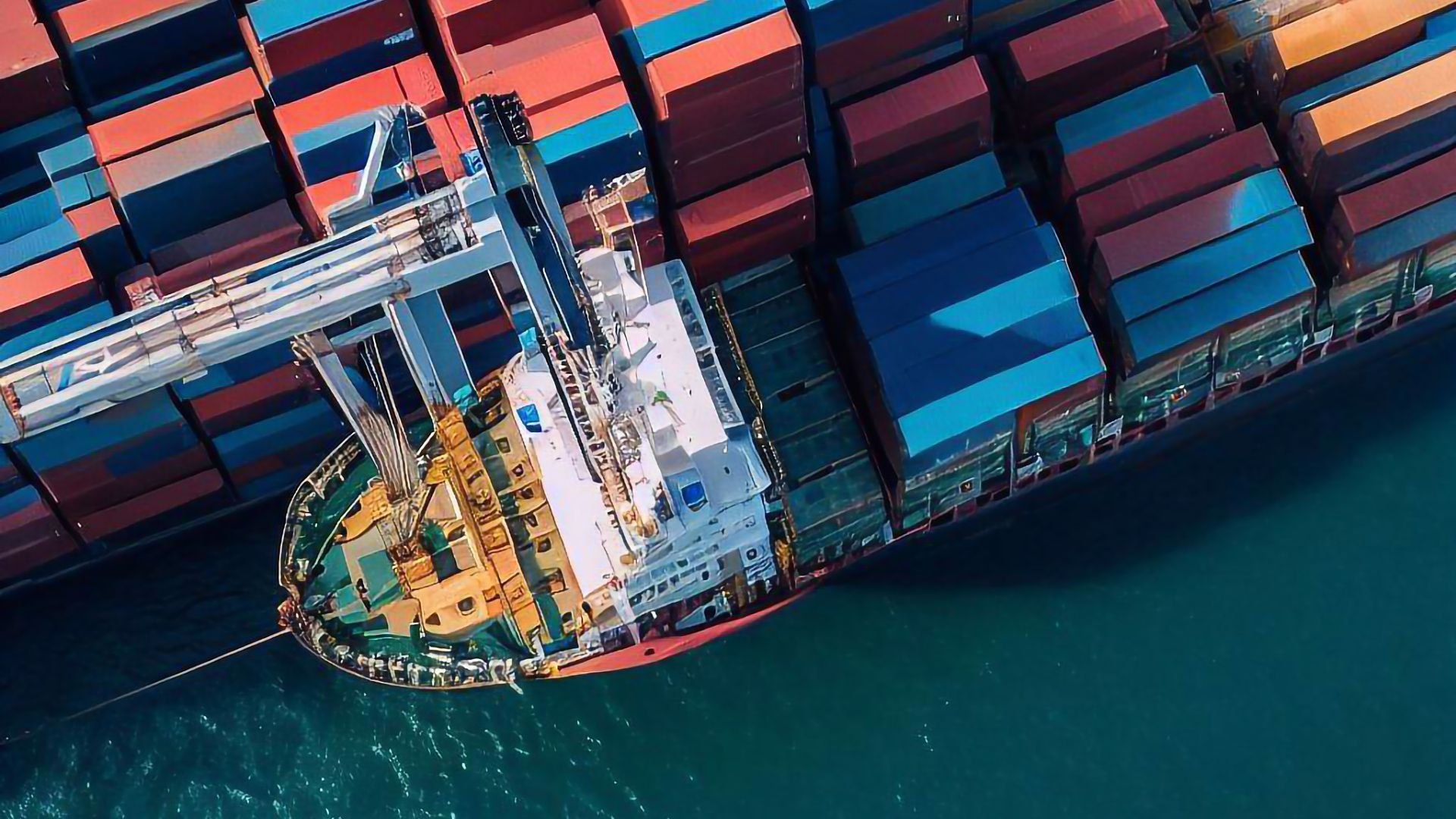 Aerial view of cargo container ship with colorful containers on deep blue water