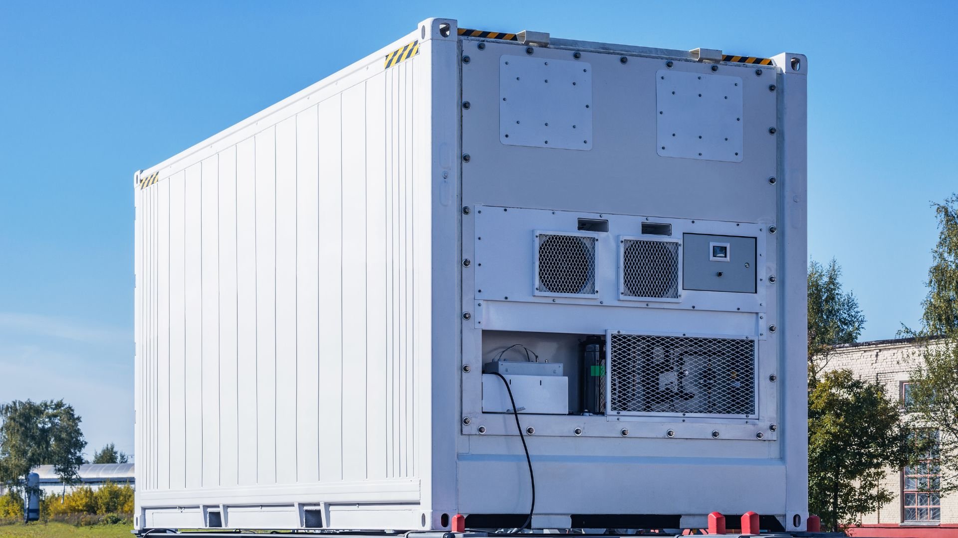 Large white refrigerated shipping container with cooling units outdoors